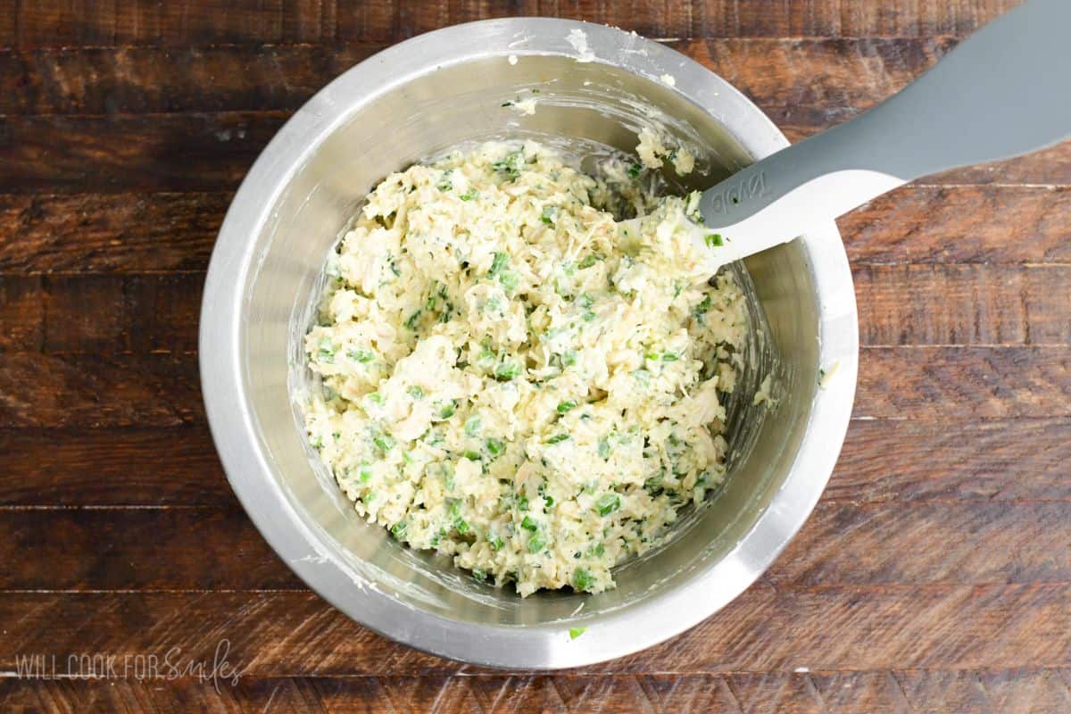 Creamy jalapeño ranch chicken filling mixed in a bowl on a wood surface.