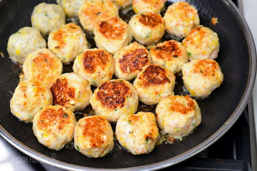 seared shrimp meatballs in a cooking pan.