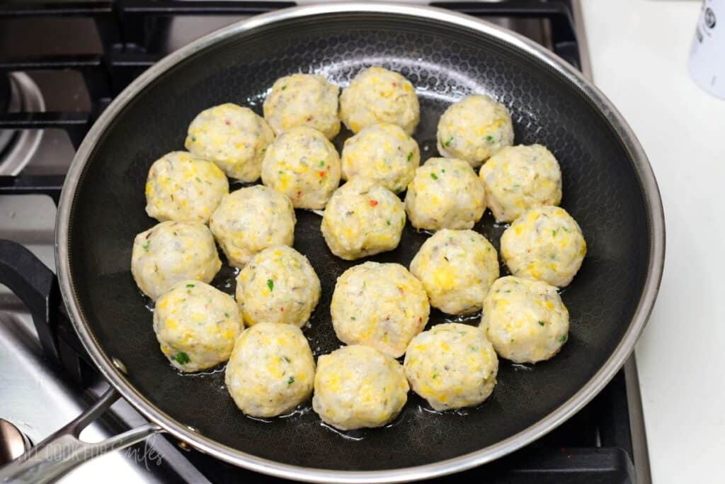 shrimp meatballs in a cooking pan before they are cooked.