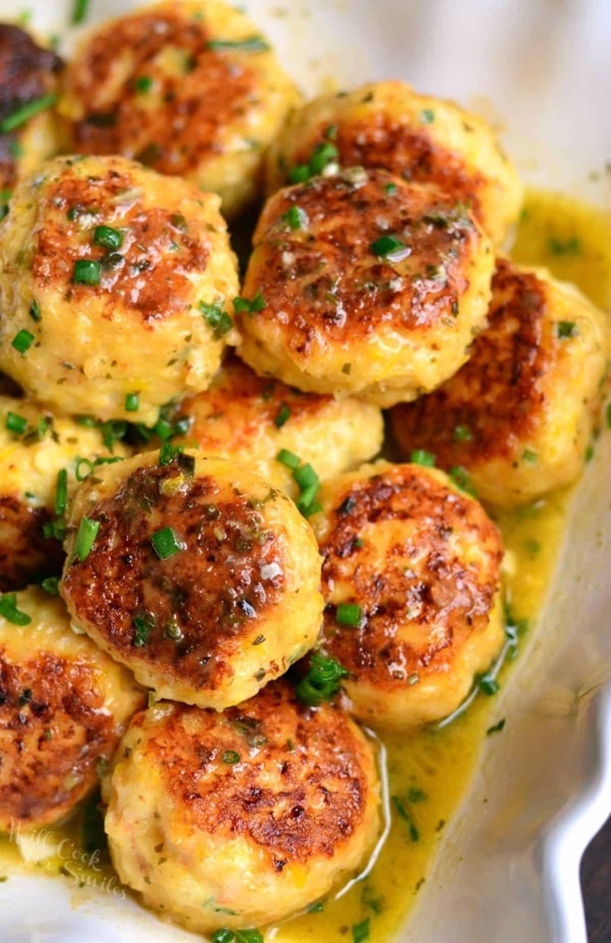 several juicy shrimp meatballs and flavorful scampi sauce in a serving bowl.