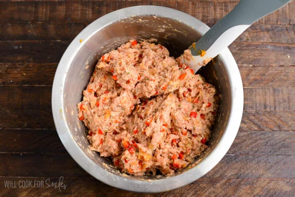 Turkey meatloaf mixture fully combined in a mixing bowl, showing ground turkey blended with diced peppers, onions, breadcrumbs, egg, and herbs before shaping.